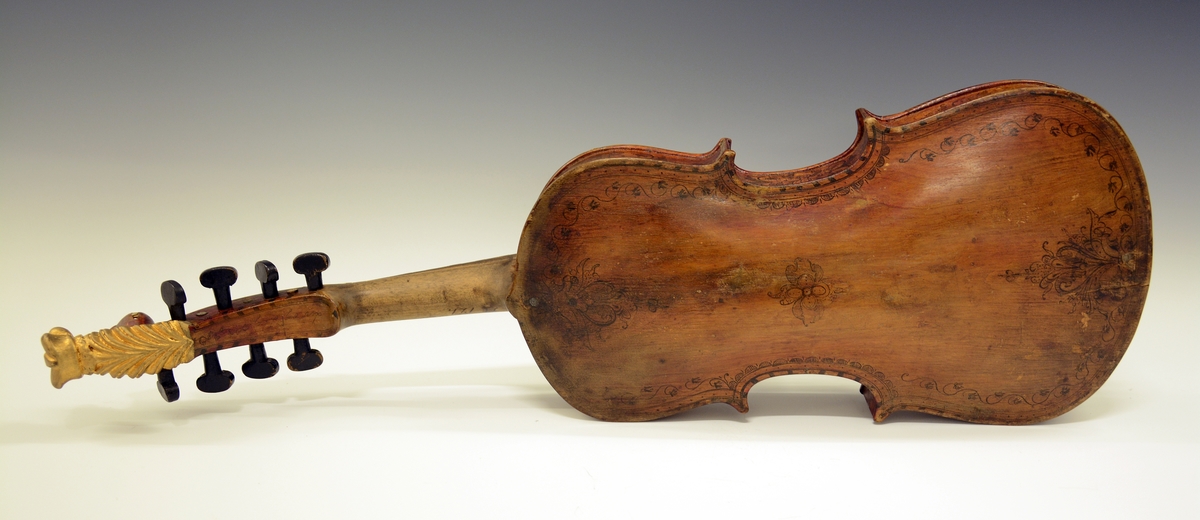 Fra protokollen: Hardingfele av den eldre, smale typen. Bruleggjingi stjerneforma, raud ferniss, stillepinnar og hovud spm vane (Hovudet nygylt). Paa merklappen inni stend: Fabrikeret af Erik Johnsen Helland i Bøe 1838. (Aarstalet ber merke av aa vera retta, serleg seinste siffer; papiret under aarstalet er vekkskrapa og talet uppnya paa berre treet.). Lok av gran, trojsk av hegg, botn av svartor, hovud av bjørk.