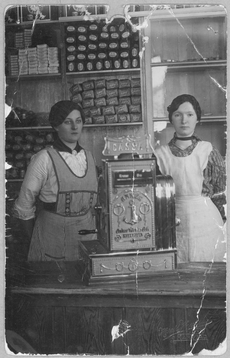 To kvinner bak en butikkdisk.