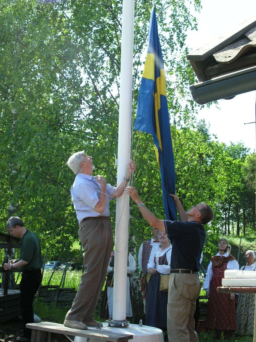Svenska flaggan hissas vid nationaldagsfirande på friluftsmuséet Disagården, Gamla Uppsala, 6 juni 2007