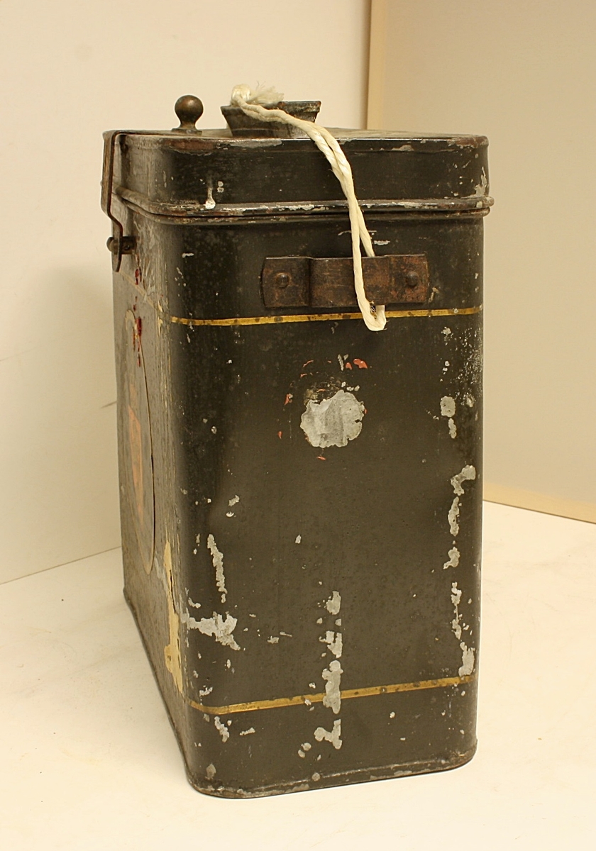 Avrundet, rektangulær boks. Den norske løve på fronten. Rester etter rødt segl. Hvit snor i plast.