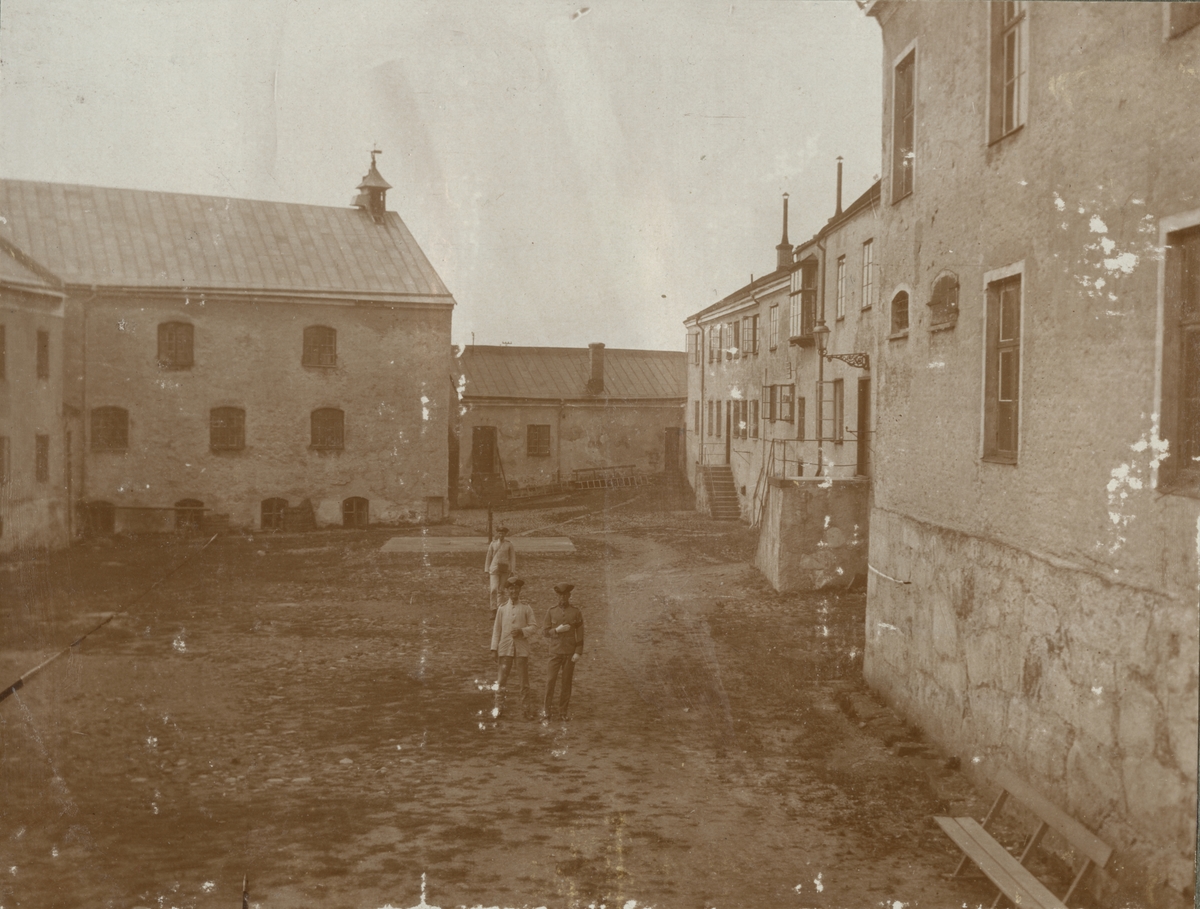 Tre soldater inne i Varbergs fästning uppställda för fotografering.