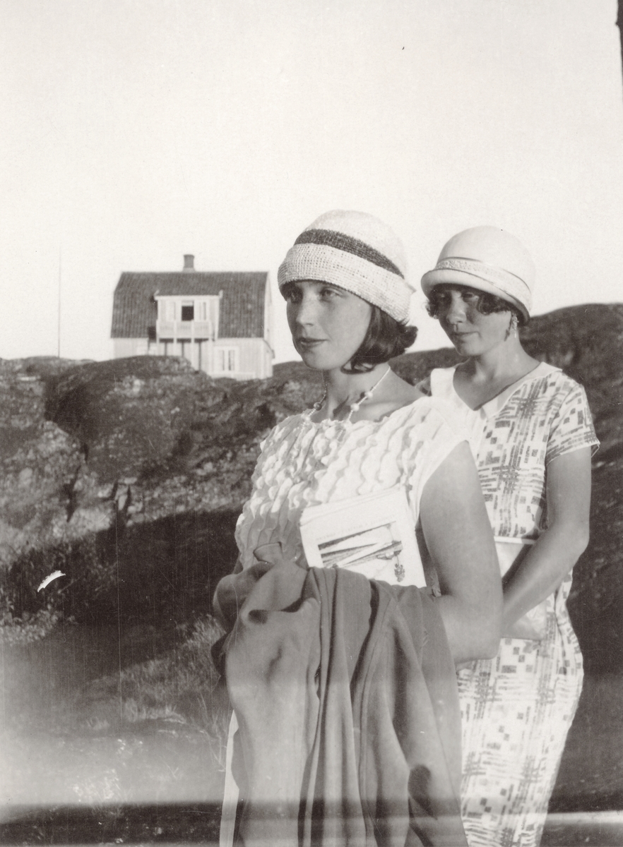 Porträtt av två flickor i ljusa sommarklänningar och hattar. Fiskebäckskil, Bohuslän.