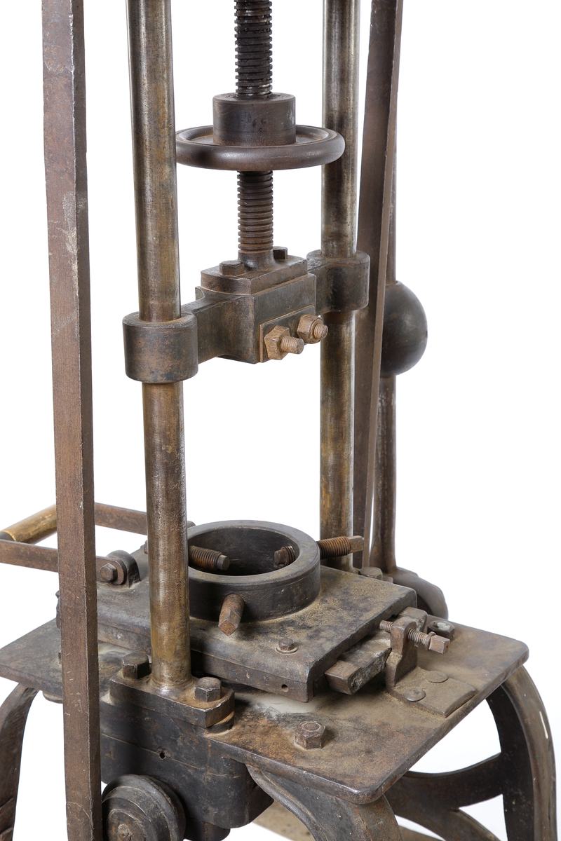 Manuell pressglasmaskin för pressning av glasföremål.
Tillverkad i gjutjärn.
Maskinen består av en "bänk" med fyra ben, varav ett är utbytt. Ovan detta två parallellt placerade rundjärn va