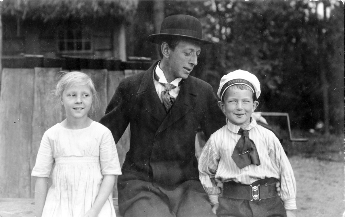 John Bauer med de två barnen som hade huvudrollerna i hans sagospel "Mats, Petter och prinsessan som fick trollöron". Teaterföreställningen för barn på Skansen i Stockholm hade urpremiär 1915-06-23.