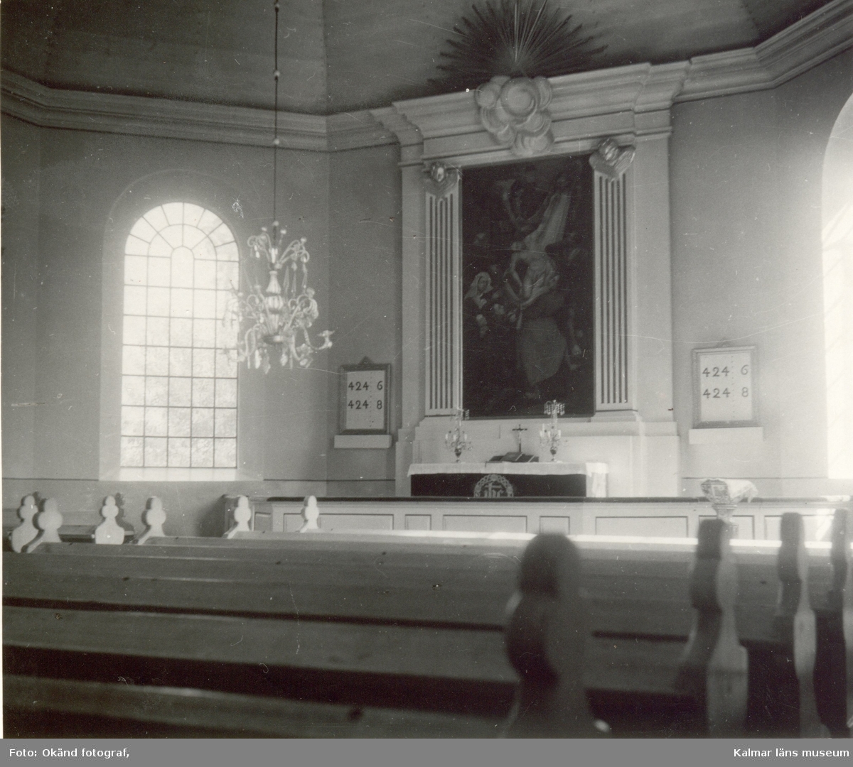 Interiör av kyrkan i Blackstad socken. Altartavlan och altare med psalmtavlor bredvid.
