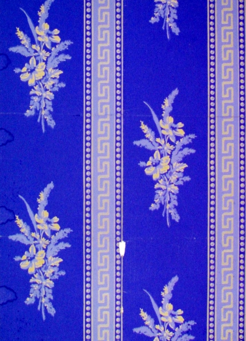 Lodrätta band dekorerade med meanderslingor och pärlstavar omväxlande med partier med blombuketter. Tryck i kobolt och ljusblått på ofärgat papper.