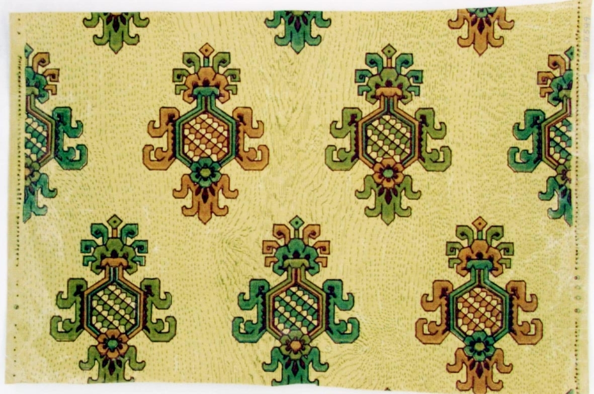 Träimiterande mönster dekorerat med ett stiliserat liljan ornament i diagonalupprepning.
Tryck i beigrått samt i två gröna och två gammalrosa nyanser på ofärgat papper.