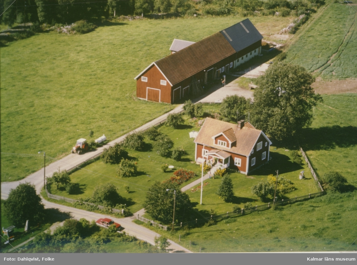 En mangårdsbyggnad med ekonomibyggnad vid åkermark i Madesjö socken.