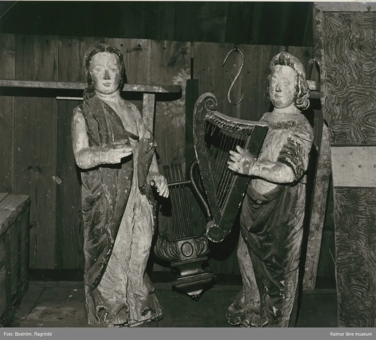 Två skulpturer från äldre orgelfasad i Gärdslösa kyrka, troligen en renovering före 1744. Mellan änglarna en lyra från läktarbröstningen. Längst till höger en bräda med (Jonas Bundi?) från bänkinredning eller läktare.