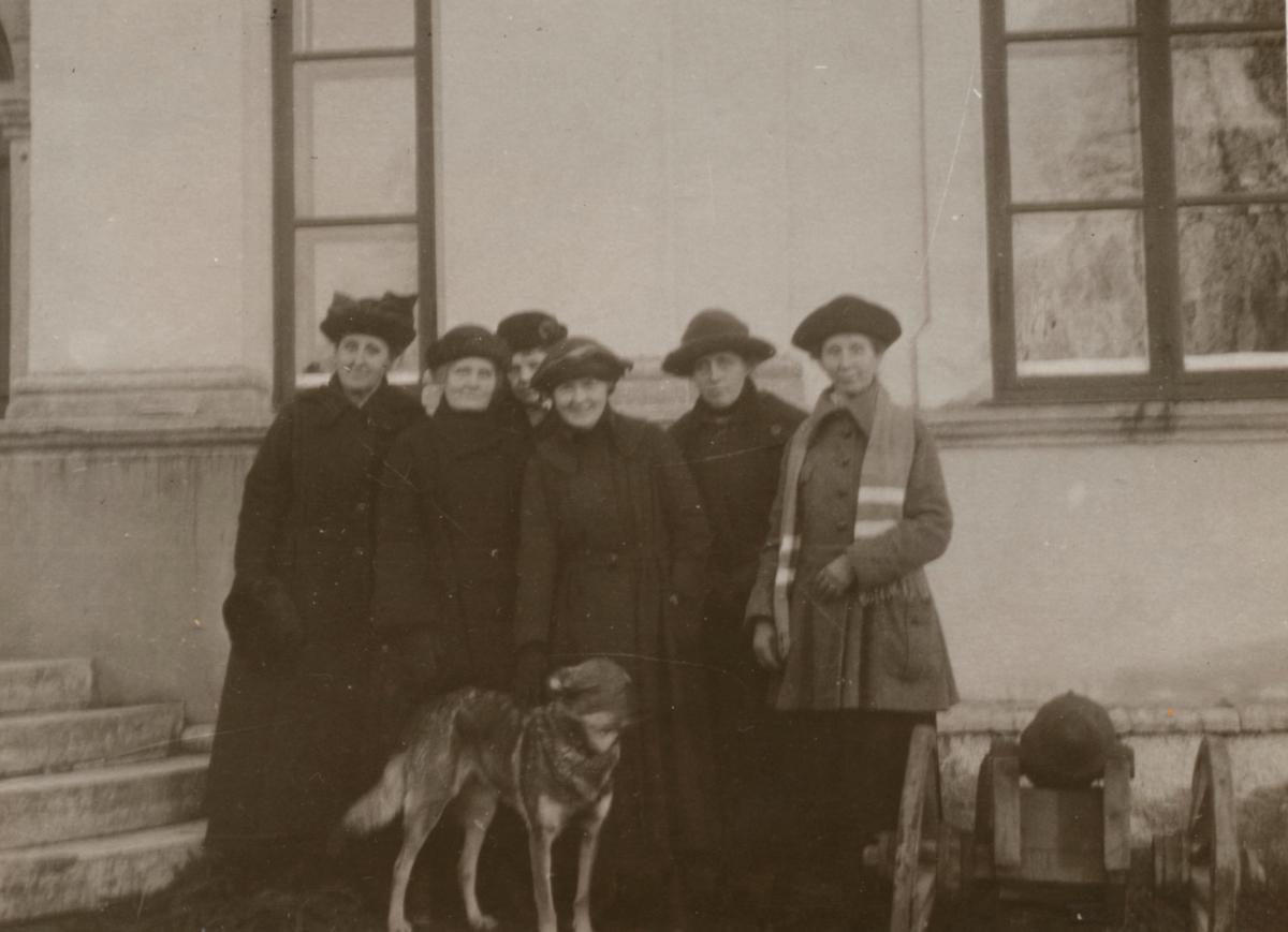 Okända kvinnor med hund, står bredvid en salutkanon.