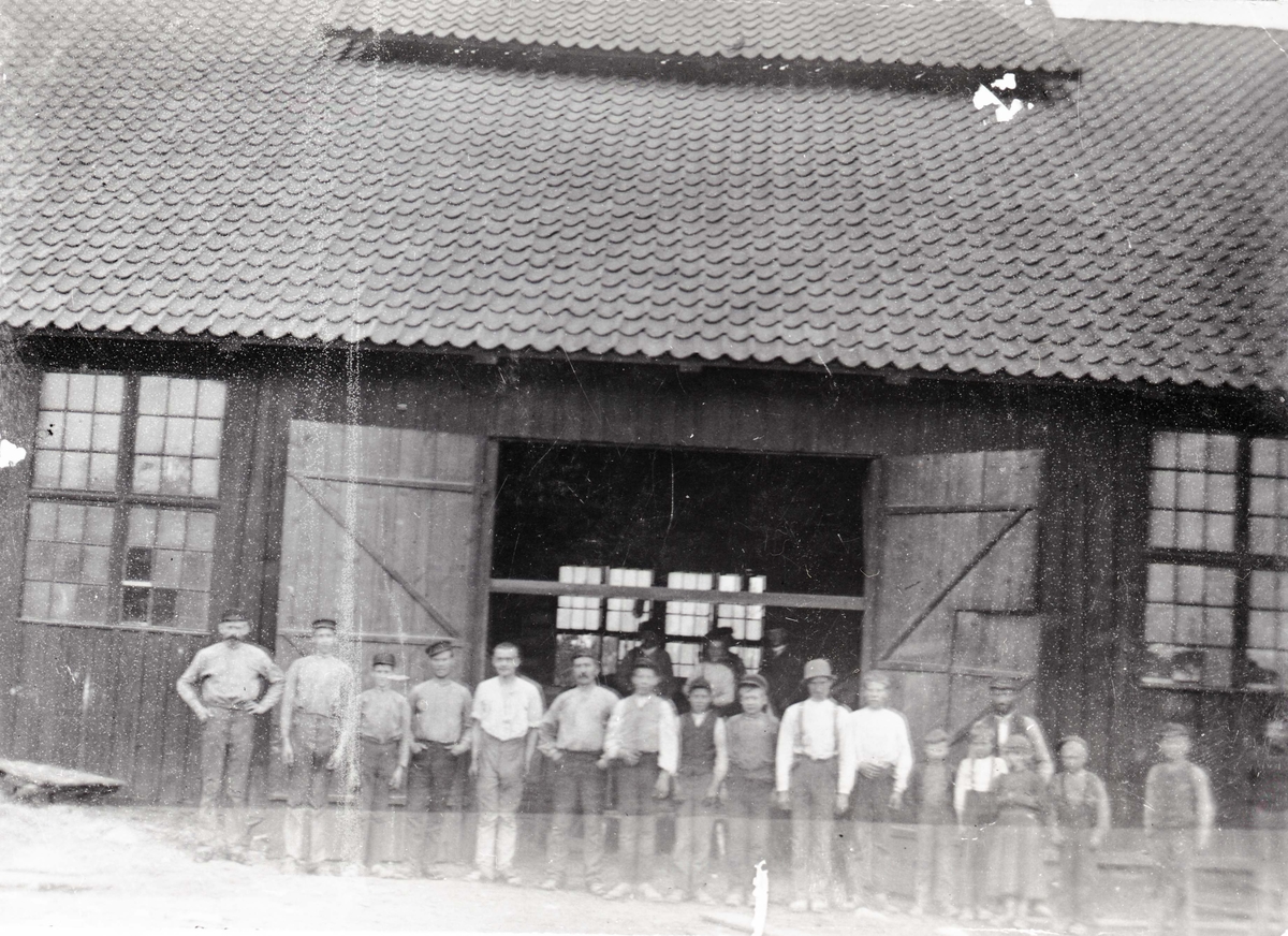 Nya hyttan med folk utanför. Tredje personen från vänster (gossen) är nuvarande (1930) fanjunkaren Ivar Berg i Hohult och första personen från vänster är fanjunkare i Bergs fader.