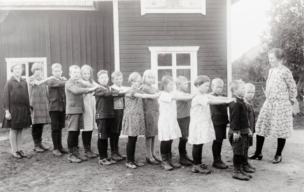 Skolbarnen och lärarinnan Ester Fransson utanför skolan år 1928.