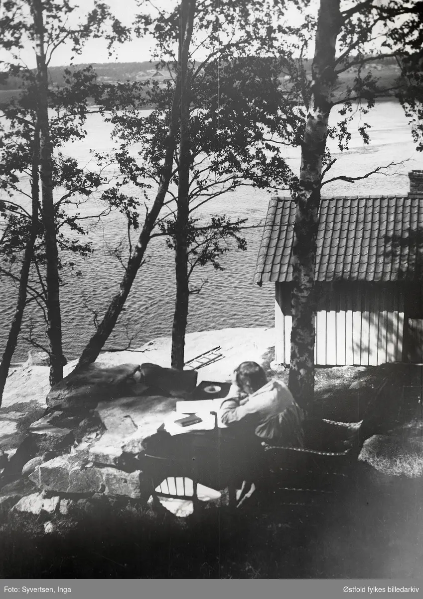 Billedhugger Gustav Vigeland er på besøk på Kultorp i Varteig, sommerdag i august 1918.

"Gustav skriver her begynnelsen av sine erindringer! "Haven", Kultorp. Der hvor han sitter var det tidligere ei smie, derfor kaldte vi den smiestanden", forteller Inga Syvertsen i 1986 (fotografen).
