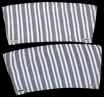Ett par manschetter av vitt bomullstyg på en sida och mönstrat tyg i svart på den andra. Ett knapphål i var kortsida.

Märkt: "341"


Neg.nr: 1989-02