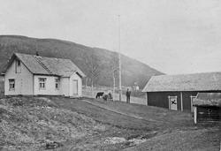 Bolighus, uthus, flaggstang, person, dyr.