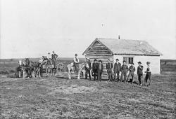 Personer, hester, vogner, hytte.