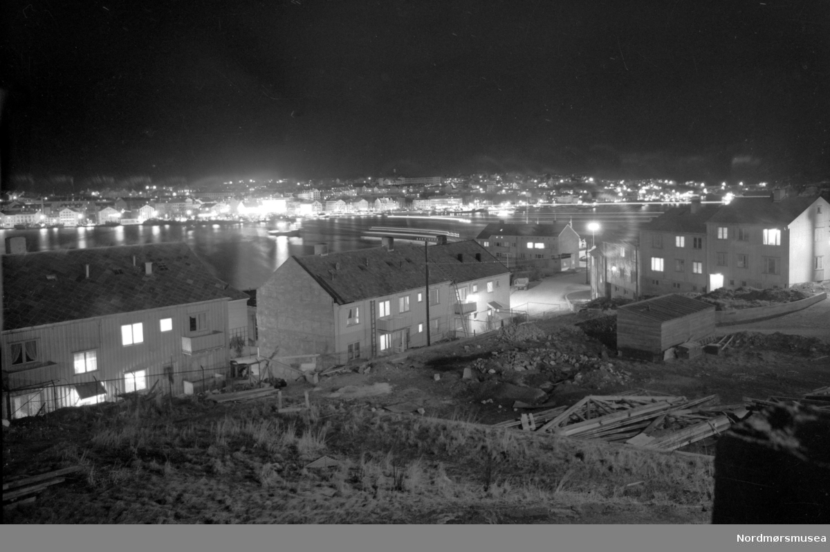 Foto fra Kristiansund. Bildet er datert 1954. Fra Nils Williams fotoarkiv. Bilde av Nordlandet i forgrunnen og Kirklandet i bakgrunnen. Fra Nordmøre museums fotosamlinger.