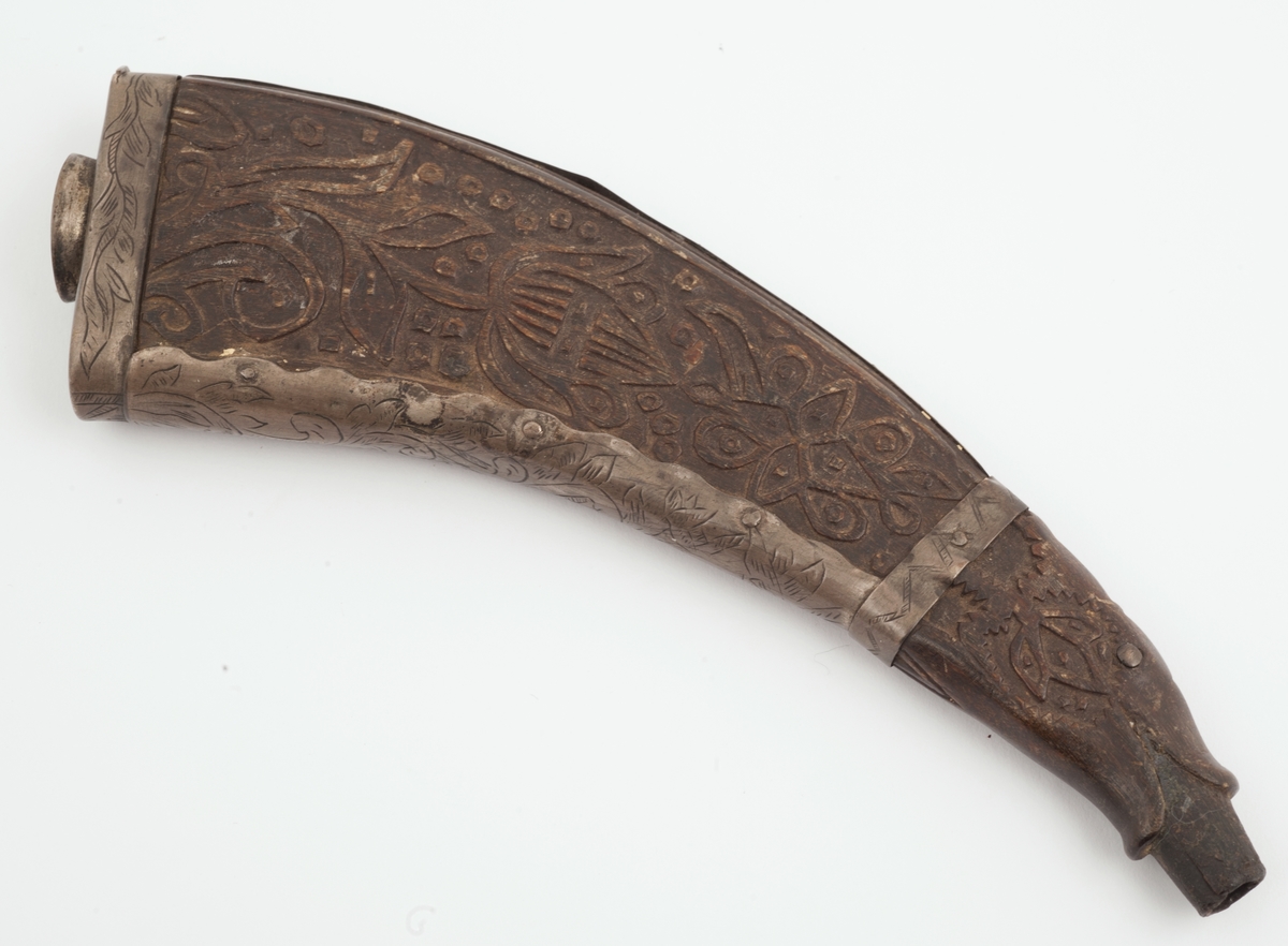 Snushorn av horn med bunn og sidebeslag av tinn. Hornet er dekorert på flatsidene med stiliserte blomsterranker. Munningen er formet som en åpen dragekjeft. Den korteste smalsiden har rankedekor på beslaget.
Bunnen er merket med et uklart monogram.
Hornet er så stort at det kan også ha vært brukt som krutthorn.