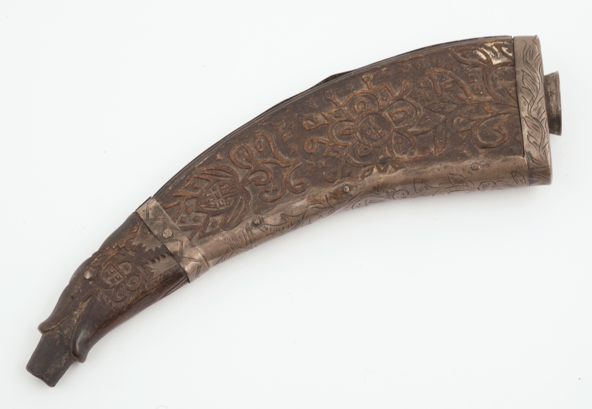 Snushorn av horn med bunn og sidebeslag av tinn. Hornet er dekorert på flatsidene med stiliserte blomsterranker. Munningen er formet som en åpen dragekjeft. Den korteste smalsiden har rankedekor på beslaget.
Bunnen er merket med et uklart monogram.
Hornet er så stort at det kan også ha vært brukt som krutthorn.