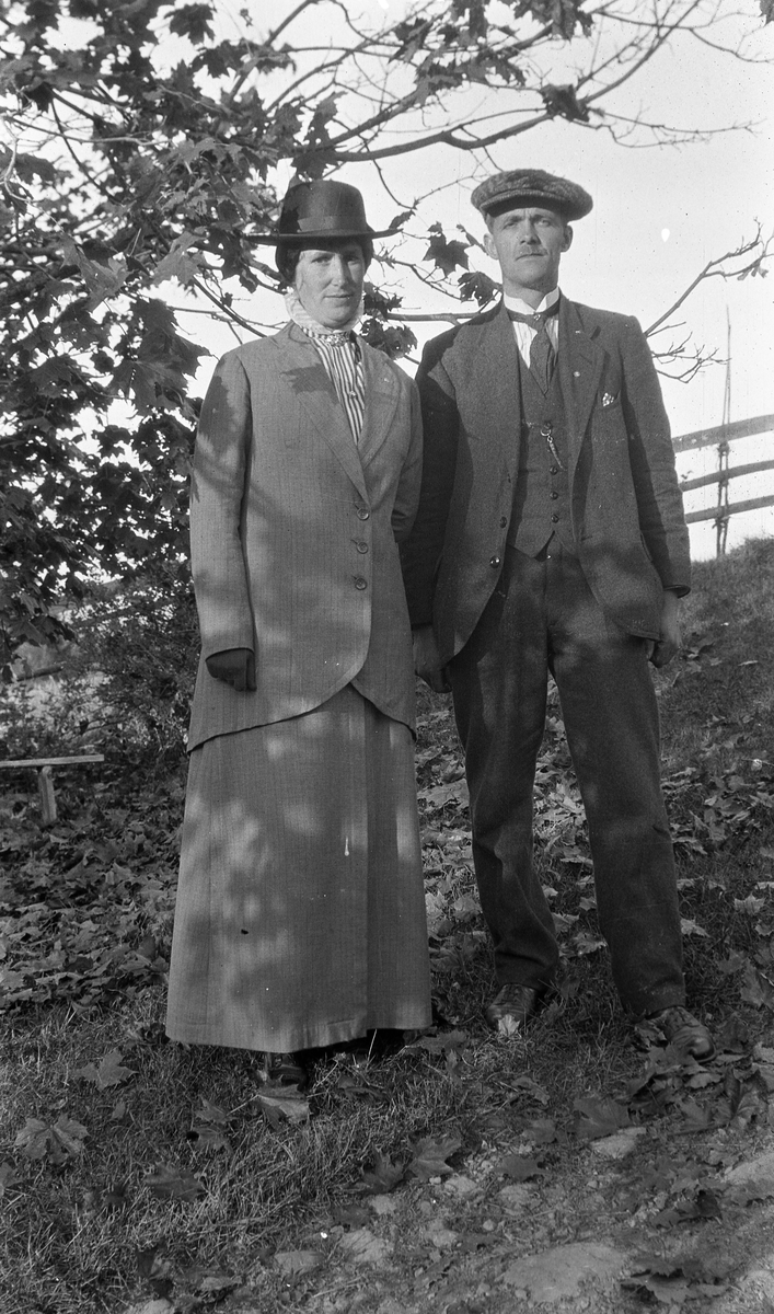 Mann og kvinne ihelfigur ved et tre. De to er Karl Edvard og Borghild Elise Woldheim. De var begge bosatt i Gjøvik, men Karl Edvard var født og oppvokst i Øverskreien. Bildet er muligens tatt ved bruket Nordeng i 1915.