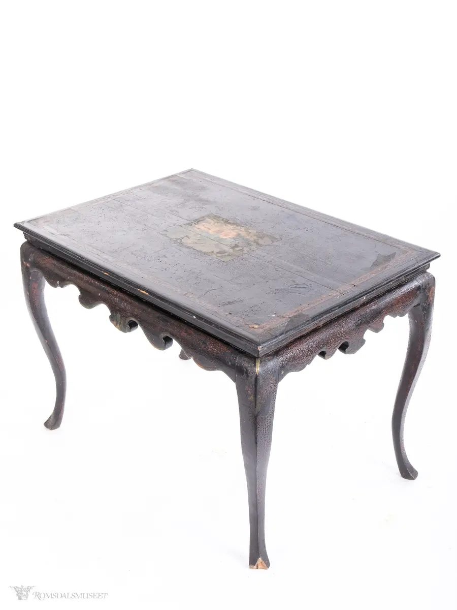 Et stilleben sentralt på bordplaten av en klase med plommer, to fersken, den ene brutt åpen, to nøtter og en fiken.