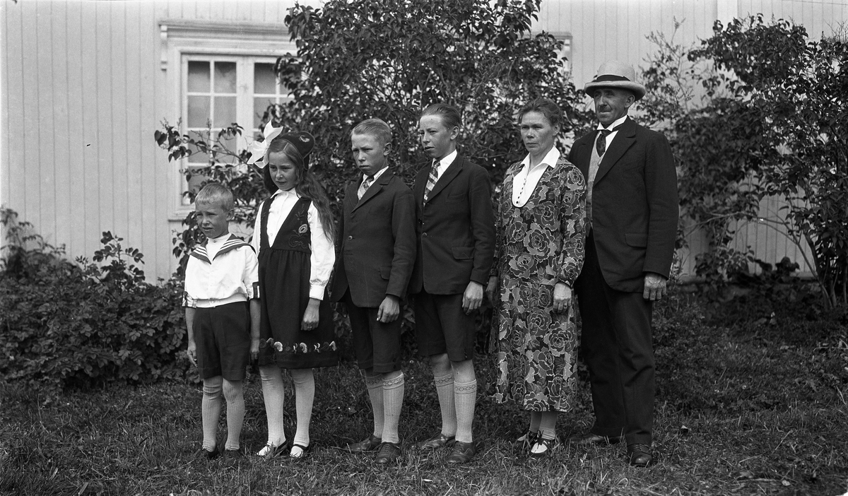 Nils og Anna Gunnerød sammen med sine fire barn foran hovedbygningen på gården Krabysanden, Østre Toten.
Fra høyre: Nils, Anna, Kåre, Leif, Nora, og Arne.