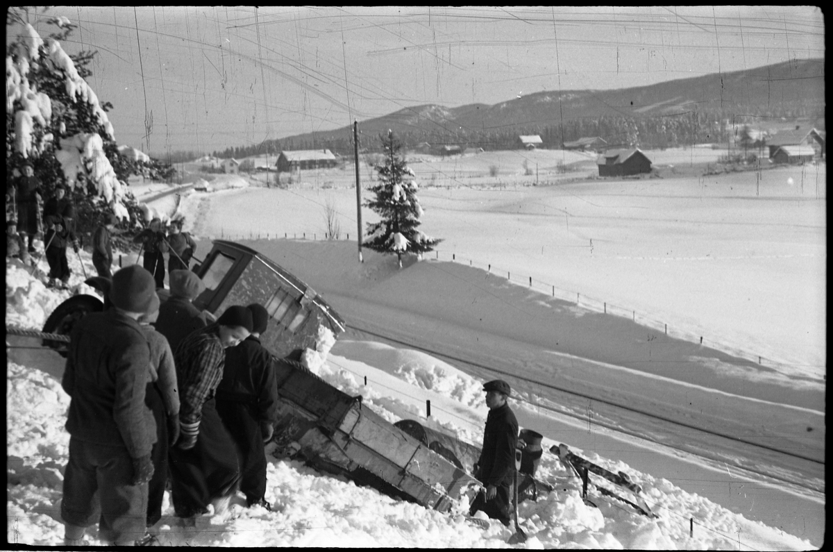 Lastebil av vegen på daværende riksveg 33, like syd for gården Smeby i Østre Toten vinteren 1939. Tre bilder. Ingen av personene er identifisert.