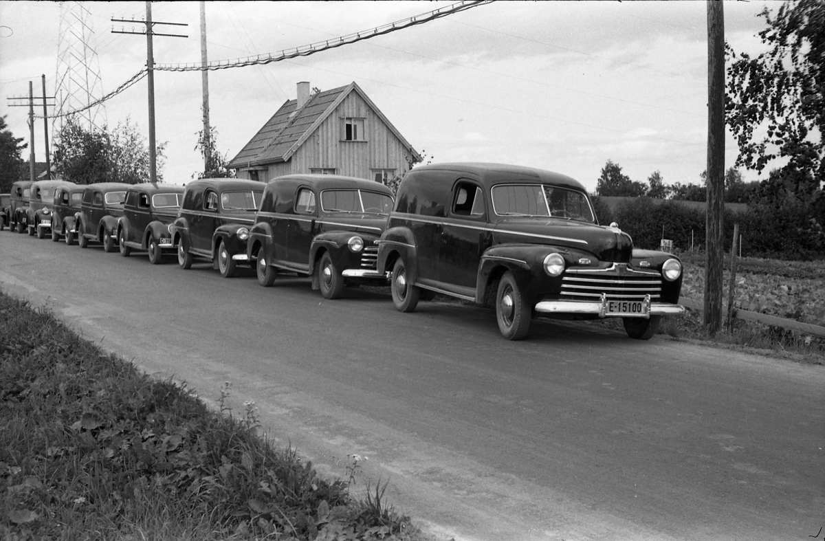 Tre bilder av en "flåte" av tilsynelatende nye varebiler.  Bilene er linet opp på vegen utenfor og foran boligen til Per Hovengen mellom Lillo og Lena. Personene på bilde nummer tre er ikke identifisert. Det dreier seg muligens om biler benyttet av ambulerende margarinselgere. Juli 1948.
Bilene skal iflg. informant være av følgende merker/modeller (bilde nr. tre som referansen): Fra venstre Tre amerikanske Ford 1946, to Ford V8 1938 stamdard, Ford V8 1937, Chevrolet 1946 Ford 1946 (de tre siste bygd på lett lastebil understell), og en ukjent førkrigsmodell, trolig ca. 1930.