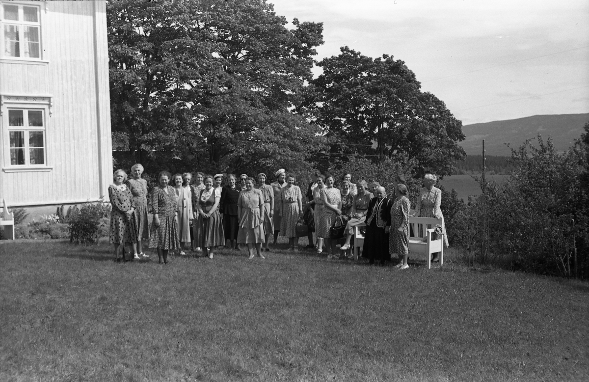 Fem bilder av en gruppe kvinner foran våningshuset og i hagen på gården Kraby østre i Østre Toten. Anledningen er muligens Borghild Nøklebys 60 års jubileum. På bilde nr. 4 står hun som nummer tre fra venstre. Til høyre for henne står nærmest mora Othilie og søstera Nora. Som nummer ni fra venstre søsteraMargit, og til høyre for henne den fjerde av søstrene, Olaug.