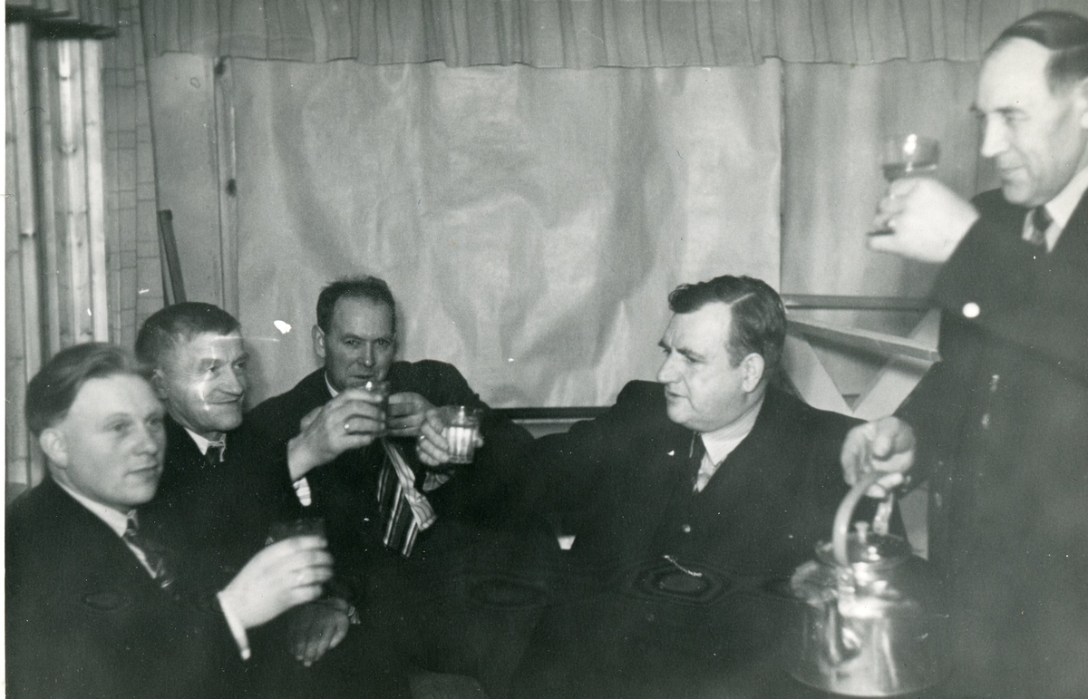 Gutta tar en skål.
frå v. Ola Rese,Engebret Hauge,Halvor Møllerplass,Ivar Bratland og Ola Eidsgaard
