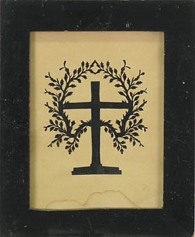 Silhuettklipp föreställande ett kors med två från stammen utgående  bladbärande grenar. Inom glas och svart ram. :: Montering/Ram: Monterad i svart ram.