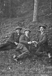 Tre unge menn koser seg med en dram i skogen. Fra. v. Haldo 