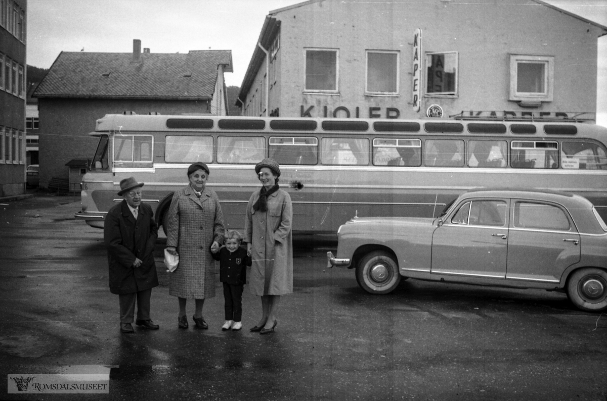 "Frå 21.08.1965"."Kongsli sitt besøk etc".Bussen i bakgrunnen tilhørte Veøy Billag. Den var registrert T-8595. Det var en DAF TB160, 1964-modell, med karosseri påbygd ved Arna Bruk. Den hadde 46 sitteplasser. Bussen gikk i mange år i ruter Molde-Åndalsnes, seinere i skoleruter. Etter at den var ferdig i rutetrafikk ble den solgt og ombygd til campingbuss. Den var registrert helt til 2006.