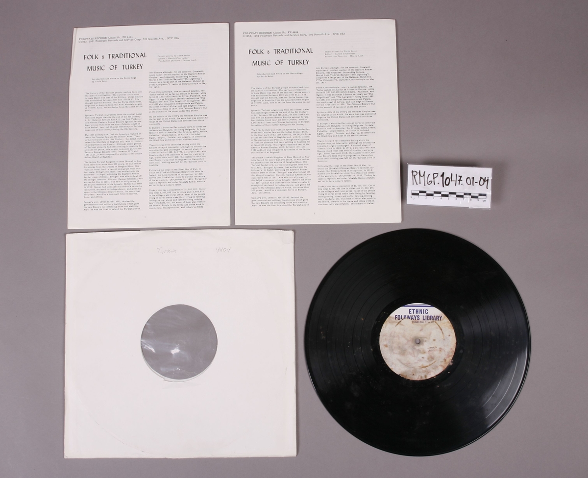 Grammofonplate i svart vinyl. Plata ligger i en papirlomme med påskriften "Trykia 4404". Ligger ved to identiske hefter, hvor på det ene har noe håndskreven påskrift (se bilde).