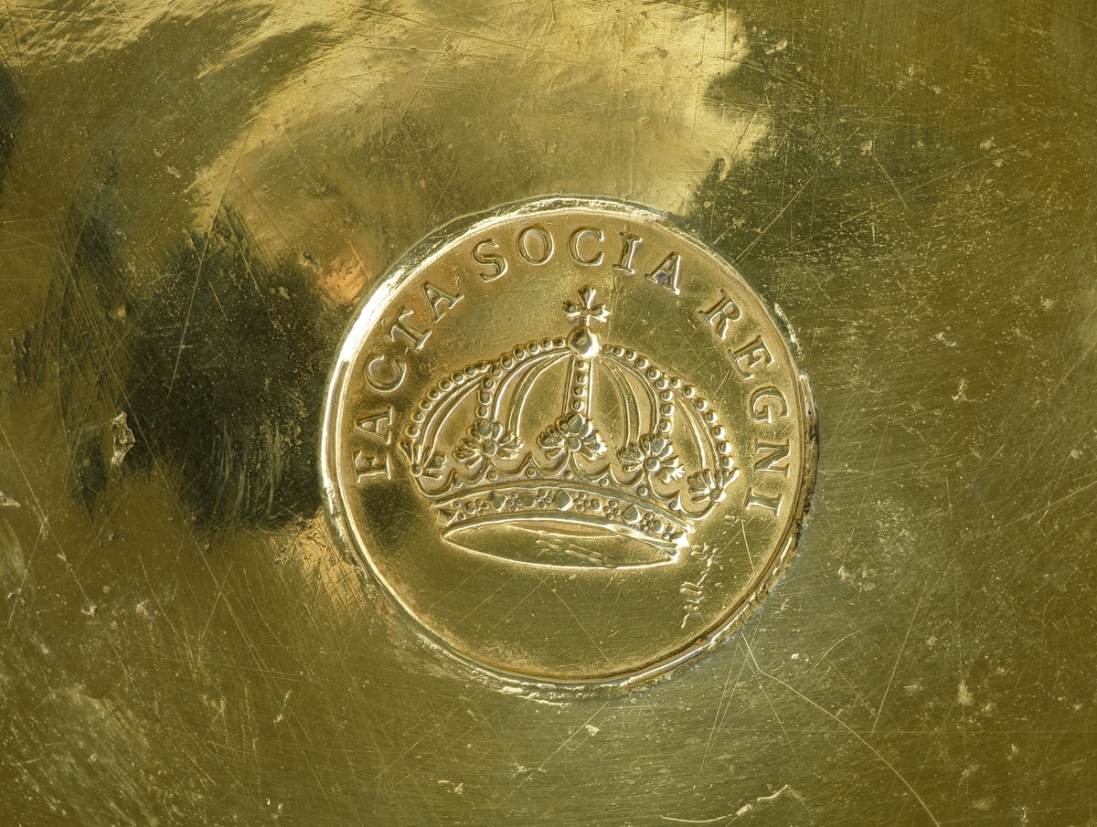 Dryckeskanna i silver.
Cylindrisk modell på tre kulfötter i form av granatäpplen med bladhölster. I locket infällt mynt: "Ulrica Eleonora, Facta Socia Regni", omgivet av ägarinitialer: "A.O.H., D.B.H....." och bred, graverad bladranka. Längs övre kannkanten sekundär inskrift: "...A.M.P. E.D. D. 23 FEBR. 1868". 
Invändigt förgylld. Hänkel prydd med blomknopp. Stämplar (mycket otydliga) på kannans undersida.