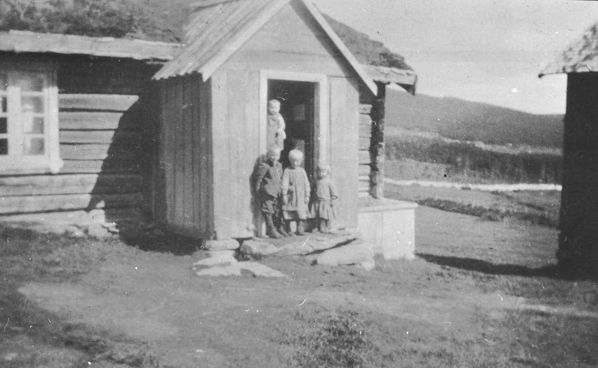 Barn i døråpning på bolighus. Oskar, Anna, Marit, bak Einar på armen til Minni Husom (synes ikke)