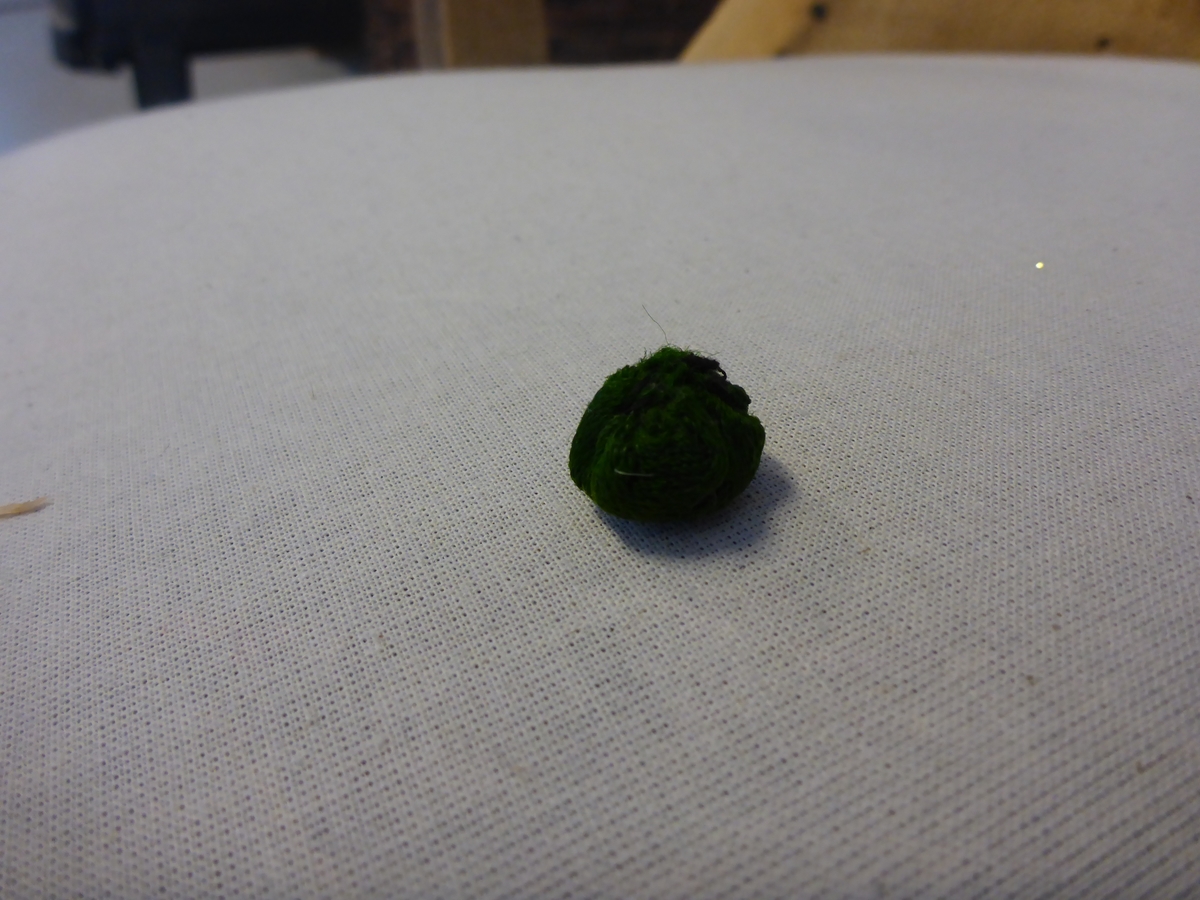 Stolen har en ramme av tre med dreide frambein som er beiset og oljet.