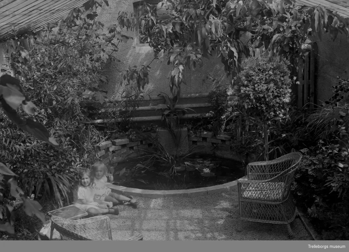 Axel Ebbes döttrar Elene och Lucia vid en damm inne i vinterträdgården i deras hem Villa Klythia.