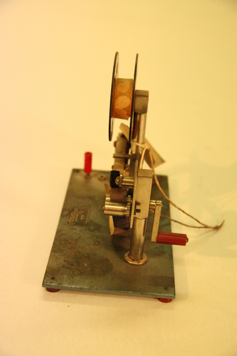 Morseapparat med sender og mottaker. Mottakeren har rull med blåpapir som setter merker ved hvert tegn. Må sveives manuelt.