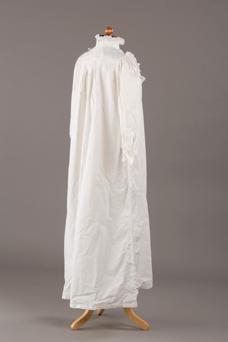 Form: Lange ermer, fotsid.

Blondekant og rysjer i halsåpning.
To knapper i metall kledd i tekstil. Mangler en knapp.