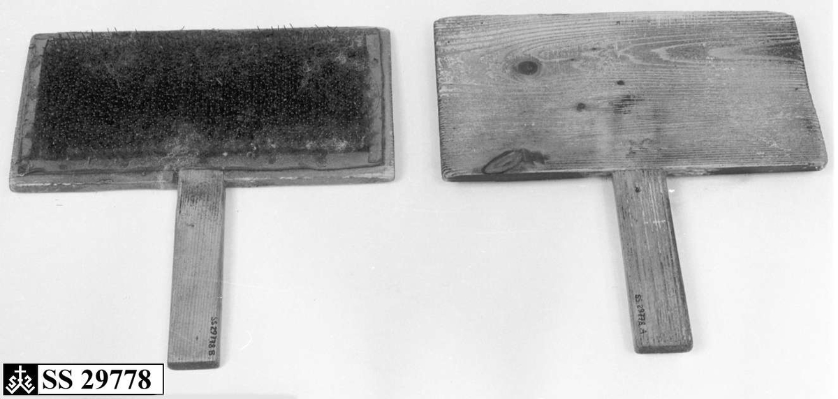To treplater hvor innsiden av begge platene er dekket av en skinnduk med tettsittende nåler. Begge treplatene har håndtak.
