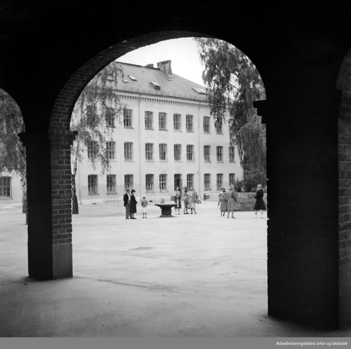 Sagene Skole. Den gamle skolebygningen fra 1861. Bildet er tatt fra inne i leskuret i den "nye" delen av skolen. Oktober 1946