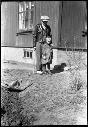 Sigurd Røisli og dattera ved husveggen hjemme på Odberg på K