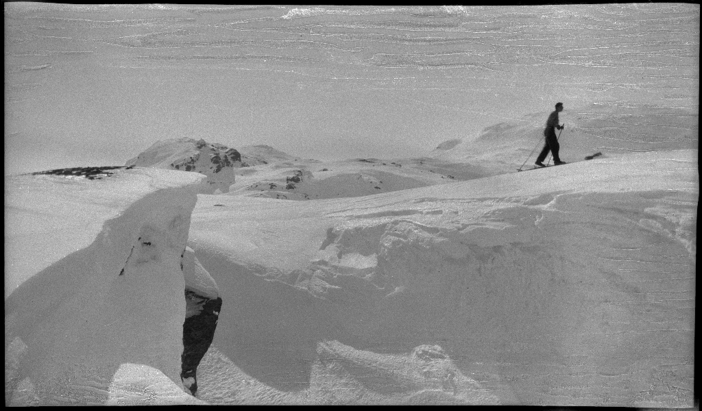 Fire unge menn på skitur fra Roalkvam til Stranddalen i Suldal. Det er bilder av hytter i fjellet, fra landskapet, lek med en hoppbakke og fra skigåing.
