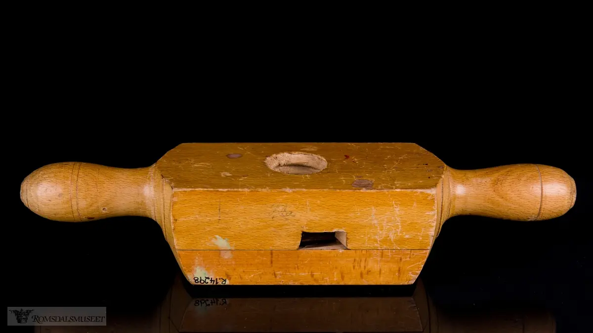 Rektangulær trekloss bestående av to deler som er festet til hverandre med skruer. En V- formet kniv er festet mellom delene og stikker fram i det gjennomgående hullet hvor treemnene gjenges. Et lite sponhus er skåret ut i skjøten mellom de to delene. Dreide trehåndtak på hver side.