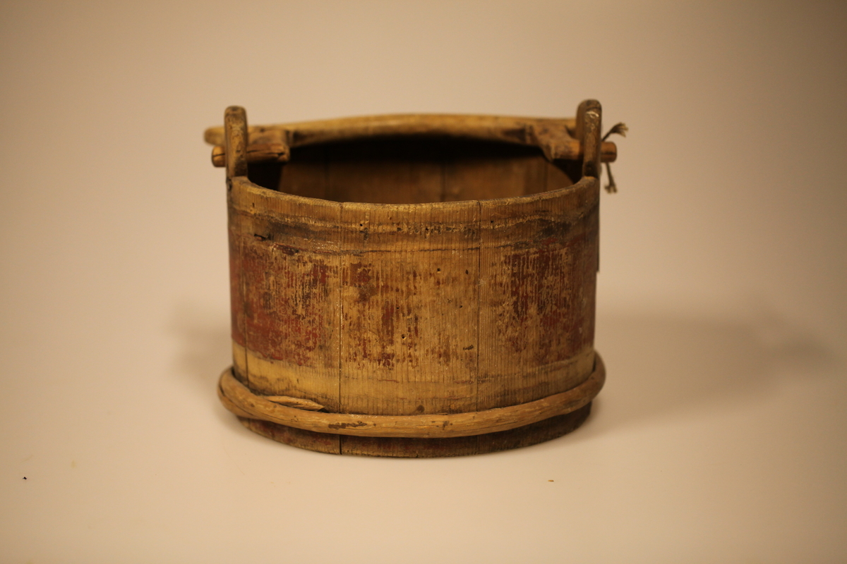 Lagget med 2 gjorder, men den øverste er borte. Bevegelig tverrhank med tretapper, to ører og innfelt bunn. Formen er rund, sylinderformet, uten lokk eller ben. Har vært påmalt rød farge. Brukt til melk.