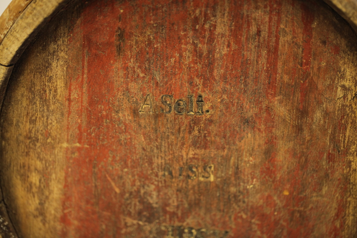 Lagget med 2 gjorder, men den øverste er borte. Bevegelig tverrhank med tretapper, to ører og innfelt bunn. Formen er rund, sylinderformet, uten lokk eller ben. Har vært påmalt rød farge. Brukt til melk.