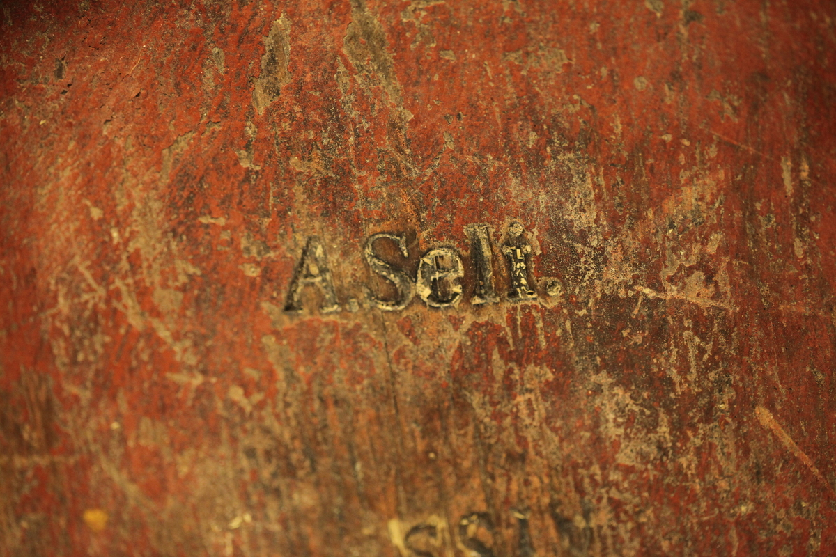 Lagget med 2 gjorder, men den øverste er borte. Bevegelig tverrhank med tretapper, to ører og innfelt bunn. Formen er rund, sylinderformet, uten lokk eller ben. Har vært påmalt rød farge. Brukt til melk.