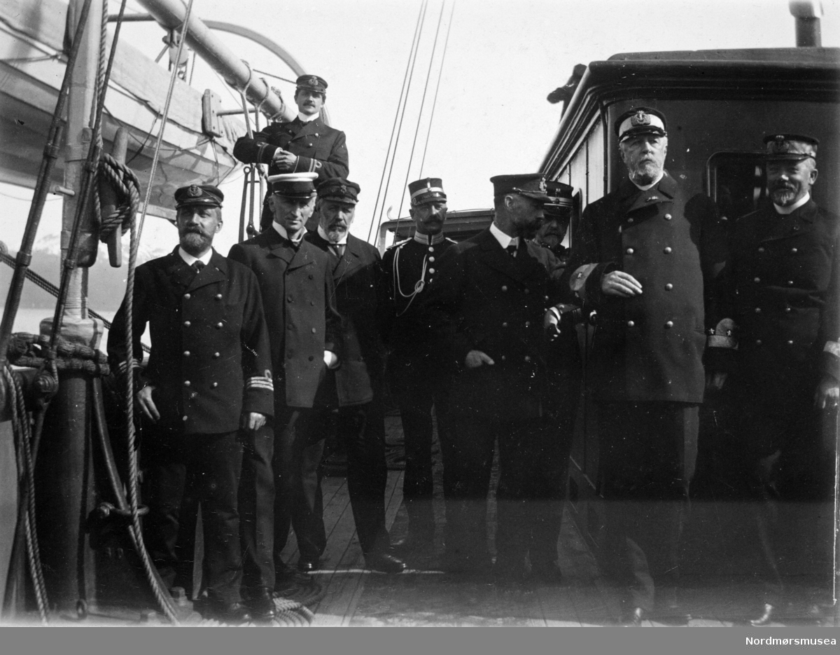 Nr. 2 fra høyre er kong Oscar 2. Militære, hoff & stab ombord på et skip. ca 1900. Samlingen har tillhørt Gert Faye-Gunnerud hvis mor var fra Walther-slekten i Kristiansund. Giver av samlingen er Tore Kristiansen. Fra Nordmøre museums fotosamlinger.