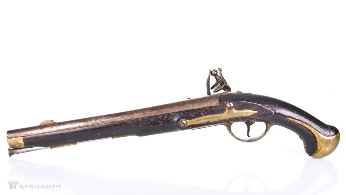 Flintlåspistol med glattboret løp, uten baksikte og med åpent korn. Skjefte av bøk med messingbeslag i enden og ved munningen. To røkner med ladestokk.